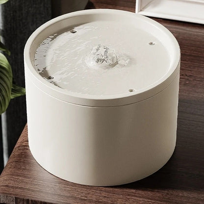 Fontanella in ceramica Ninfeo color Gesso su un mobile in legno, con l'acqua che sgorga al centro
